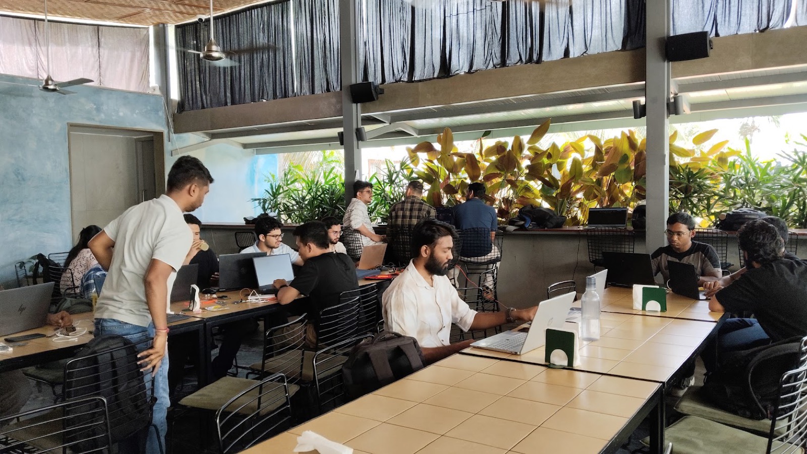 Engineers working on laptops and breadboards at the Coding and Kombucha hardware jam